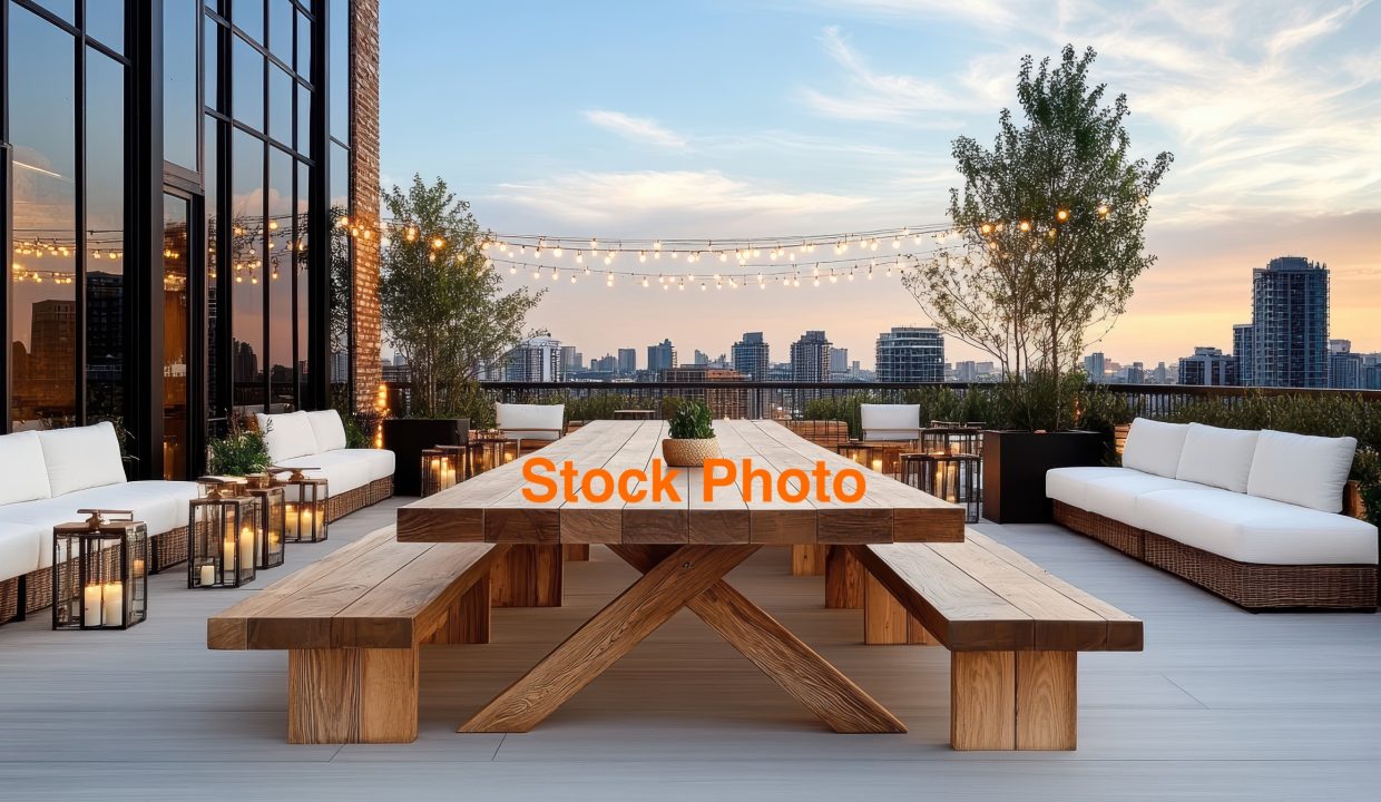 Spacious wooden rooftop table with communal seating, surrounded by cozy lanterns and city