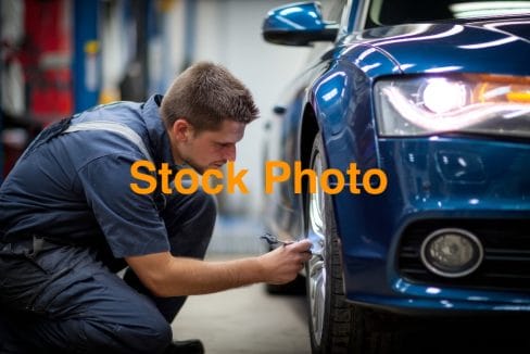 5. vecteezy_a-man-is-fixing-a-car-tire-in-a-garage_71101030